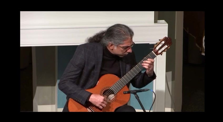 Mohammadali Masjedi playing classical guitar, profile view