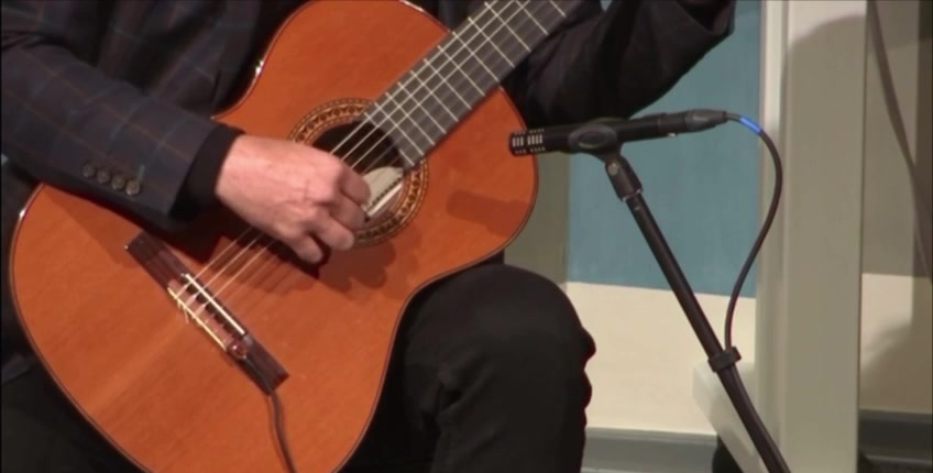 Classical guitar and plucking hand, close detail