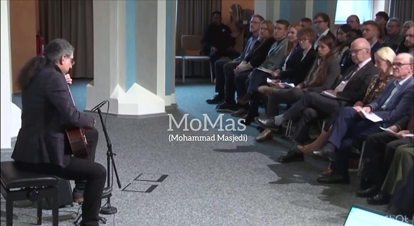 Mohammadali Masjedi on a concert hall stage with classical guitar